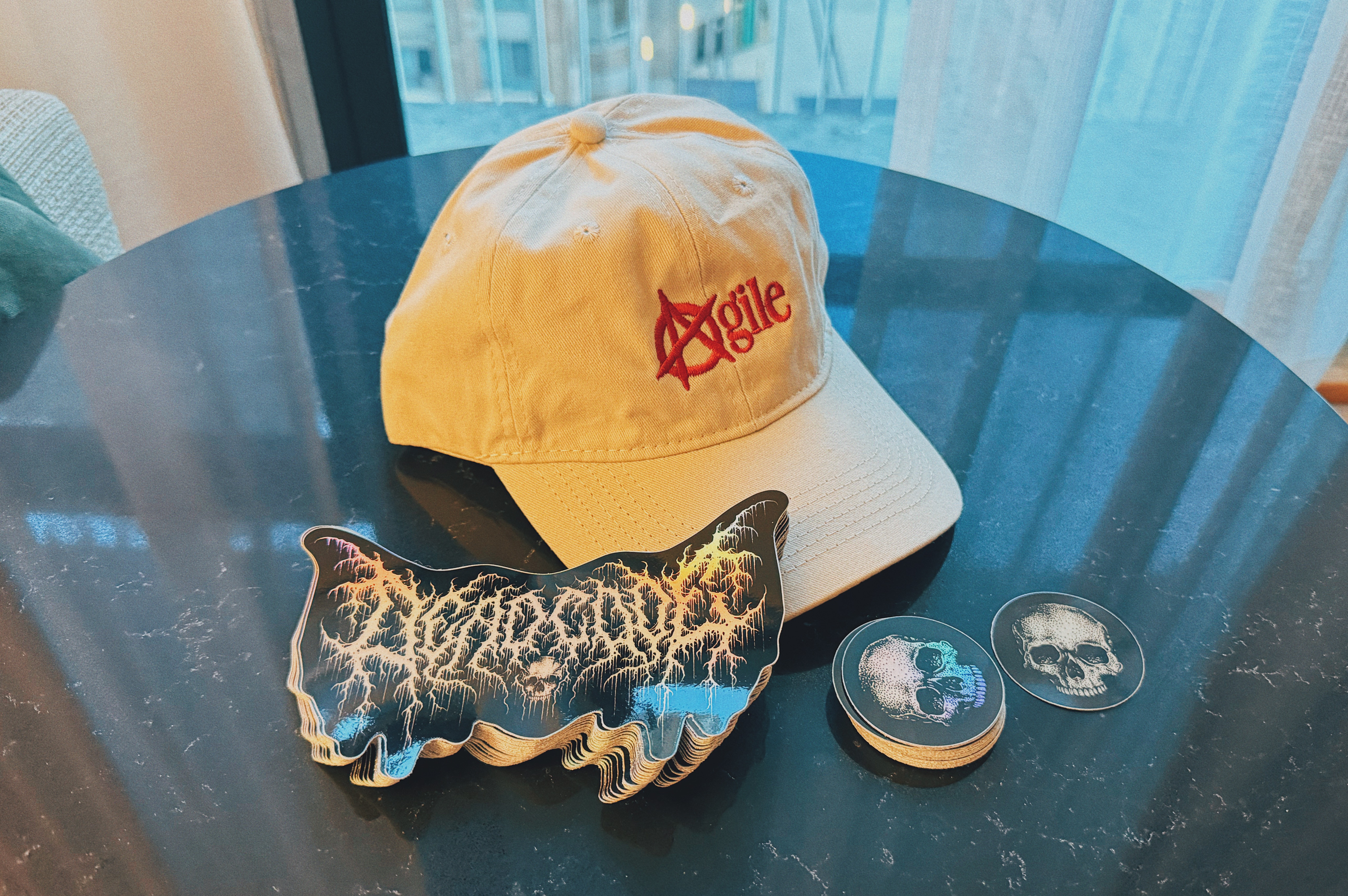 the giveaway contents, showing the hat you'll get along with examples of the stickers you'll receive